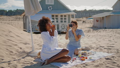 Joyful-girls-taking-pictures-on-sandy-beach.-Happy-lgbt-couple-enjoying-vacation