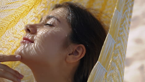 Romantic-girl-enjoying-sunlight-in-hammock-closeup.-Vertical-dreamy-woman-look