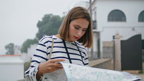 Focused-girl-checking-map-on-city-street.-Beautiful-tourist-exploring-town