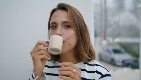 Portrait-woman-enjoying-coffee-in-european-old-town.-Smiling-girl-posing-relax