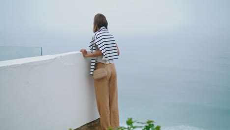 Girl-looking-seaside-view-on-cliff-top.-Summer-tourist-admiring-ocean-landscape