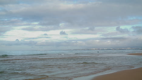 Sea-waves-hitting-beach-under-cloudy-sky.-Peaceful-ocean-coastline-with-rippling
