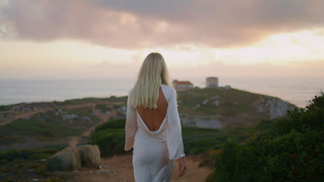 Flirting-blonde-walking-castle-landscape-closeup.-Sensual-woman-looking-camera