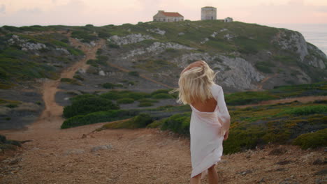 Excited-lady-stepping-chateau-landscape-vertically.-Blonde-woman-running-evening