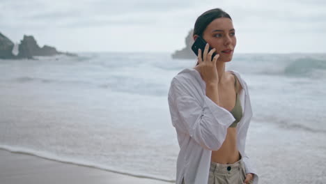 Girl-speaking-telephone-ocean-waves-close-up.-Woman-talking-phone-vertically