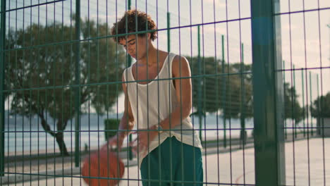Basketball-player-training-stadium.-Curly-hair-man-playing-ball-vertical-shot