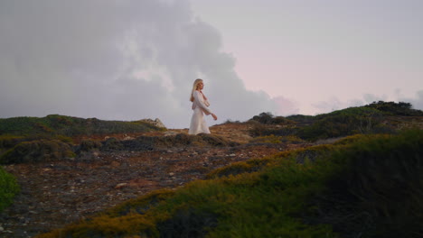 Serene-model-going-nature-cloudy-sky-background.-Vertical-girl-walk-sunset-hill