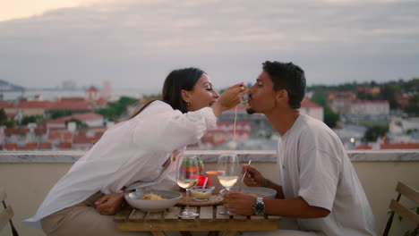 Positive-lovers-eating-balcony-closeup.-Couple-celebrating-anniversary-vertical
