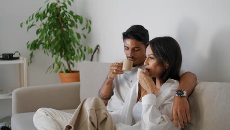 Happy-lovers-enjoying-tea-at-home-closeup.-Love-couple-relaxing-with-coffee-cups