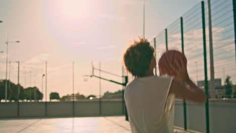 Sportlicher-Typ,-Der-Basketball-Im-Sonnenlicht-Spielt,-Nahaufnahme.-Teenager-Springtraining