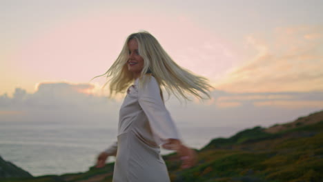 Blonde-girl-posing-evening-ocean-background-closeup.-Model-turning-around-nature