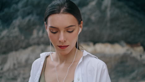 Calm-woman-wearing-headphones-in-front-sandy-hill-closeup.-Woman-listening-music