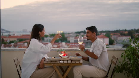 Happy-spouses-drinking-champagne-at-terrace-zoom-out.-Gentle-man-treating-wife