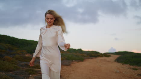 Cheerful-girl-running-hill-vertical-closeup.-Happy-woman-moving-across-sunset