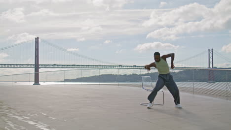 Flexible-man-training-embankment-alone-vertical-shot.-Man-contemporary-dance