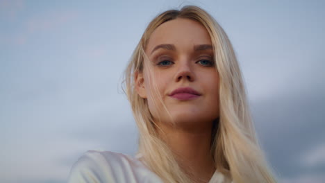 Blonde-model-posing-sunset-sky-background-portrait.-Girl-face-looking-camera
