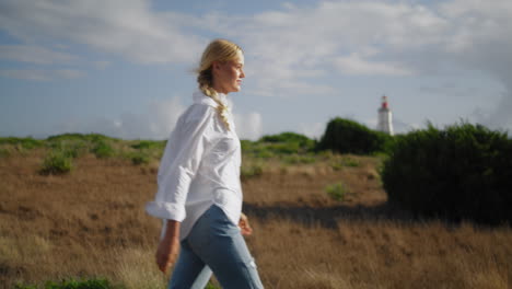 Blonde-woman-walking-field-vertical-closeup.-Carefree-tourist-watching-meadow