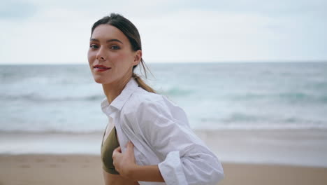 Happy-woman-walking-beach-in-white-shirt-closeup.-Gentle-lady-stroll-vertical