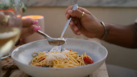 Unknown-man-eating-spaghetti-vertically-closeup.-Woman-hands-decorating-food