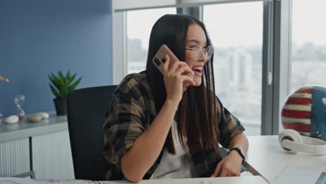 Excited-manager-gossiping-phone-in-office-closeup.-Smiling-woman-calling-mobile