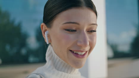 Girl-answering-call-headphones-on-city-street-closeup.-Woman-talking-headset.