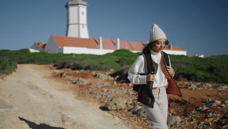 Girl-traveling-lighthouse-island-with-backpack-alone.-Beautiful-tourist-walking