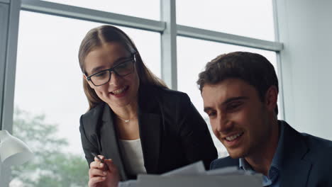 Two-business-partners-checking-report-closeup.-Smiling-mentor-helping-employee