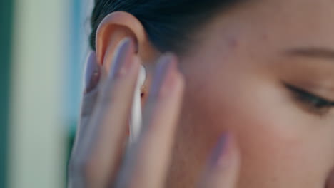 Closeup-woman-putting-wireless-earphone-into-ear.-Girl-wearing-headset-for-music