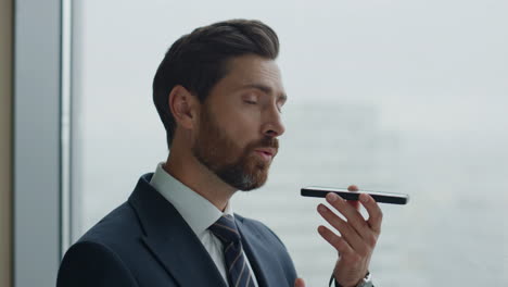 Confident-man-speaking-phone-standing-at-office-window-closeup.-Manager-working