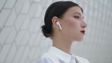 Portrait-gorgeous-successful-businesswoman-in-wireless-earbuds-looking-camera.