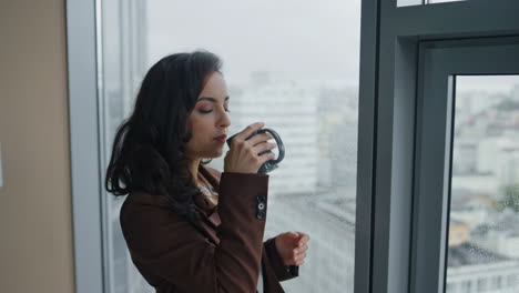 Geschäftsfrau-Trinkt-Kaffee-Und-Steht-Neben-Einem-Panoramafenster-Im-Büro,-Nahaufnahme.
