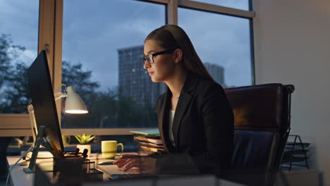 Beautiful-manager-typing-computer-in-dark-office.-Pensive-woman-ponder-business