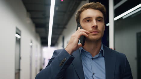 Closeup-businessman-answering-call-leaving-conference-room.-Serious-man-lawyer