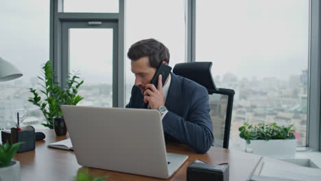 Entrepreneur-have-phone-negotiation-sitting-at-office-desk-close-up.-Man-talking