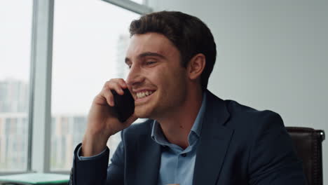 Smiling-executive-talk-phone-in-office-closeup.-Happy-manager-celebrate-contract