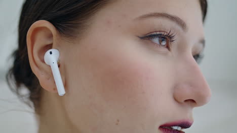 Closeup-beautiful-woman-face-with-wireless-earbuds-in-ears.-Gorgeous-young-girl.