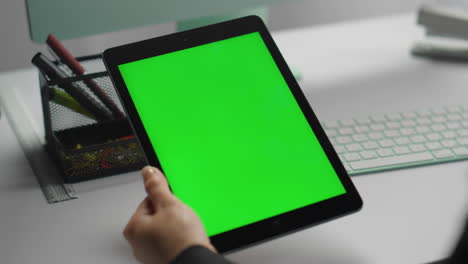 Manager-using-mockup-tablet-with-green-screen-closeup.-Hands-hold-chroma-key