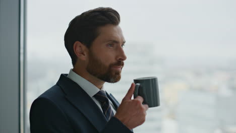 Businessman-having-inspiration-coffee-break-looking-at-cityscape-close-up.
