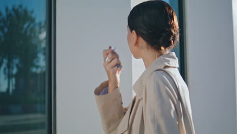 Woman-taking-wireless-earbuds-watching-window-reflection-outdoors.-Stylish-girl