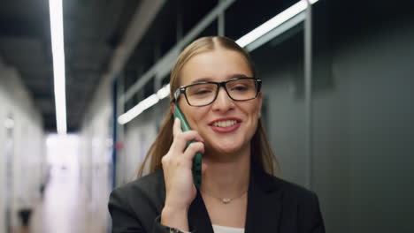 Happy-businesswoman-talking-phone-in-office-closeup.-Smiling-manager-walking