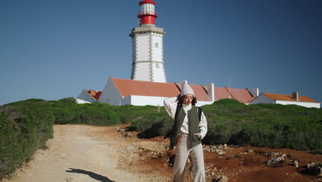 Tourist-girl-walking-lighthouse-pathway-on-sunny-day.-Serene-woman-rest-spring