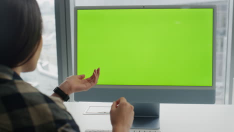 Gesturing-startuper-video-calling-at-chromakey-pc-office.-Woman-virtual-call