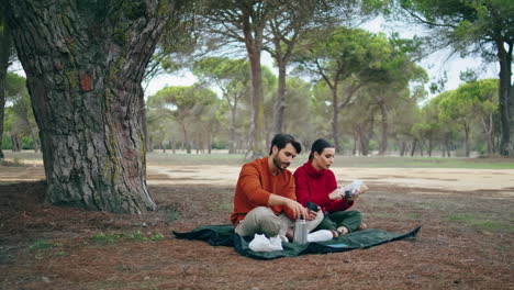 Young-couple-autumn-picnic-in-park-at-blanket-vertical.-Family-romantic-weekend