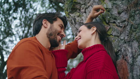 Happy-smiling-couple-standing-forest-tree-vertical-close-up.-Family-laughing