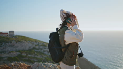 Happy-tourist-speaking-smartphone-at-ocean-sunset.-Joyful-girl-enjoy-landscape