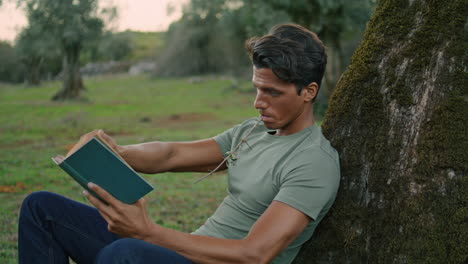 Hombre-Enfocado-Volteando-El-Libro-Por-La-Noche-Parque-De-Cerca.-Chico-Leyendo-Literatura-En-La-Naturaleza