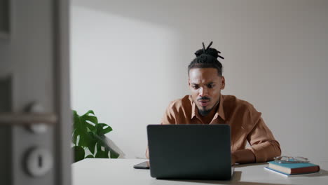 Friendly-freelancer-explaining-laptop-home-closeup.-African-american-man-talking