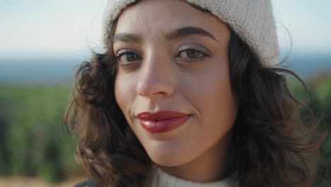 Pretty-tourist-posing-outdoors-in-knitted-hat-closeup.-Cheerful-girl-enjoying