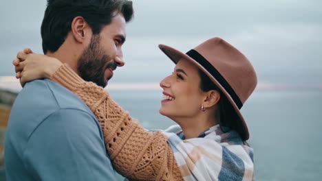 Couple-have-fun-coast-hugging-closeup.-Smiling-pair-standing-in-front-gray-ocean