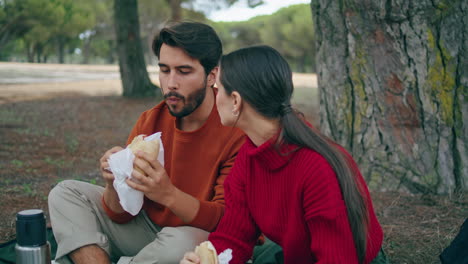Romantic-family-eating-picnic-in-park-vertical-close-up.-Couple-enjoy-snacks